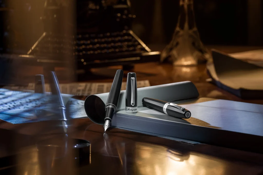 Stilou Montegrappa Magnifica pe un birou din lemn, cu caiet și elemente vintage în fundal