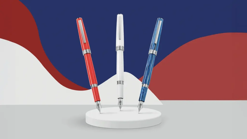 Stilouri Montegrappa Armonia în roșu, alb și albastru, expuse pe fundal modern.