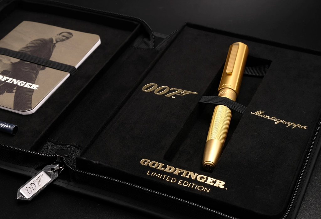 Set stilou Goldfinger 007 Montegrappa, ediție limitată, finisaj auriu, prezentat în husă premium cu branding James Bond.